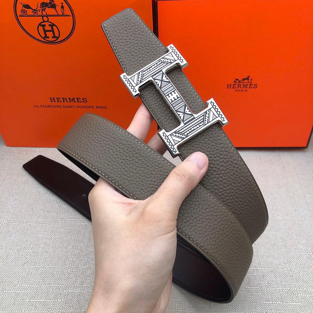 Taupe leather belt held up with silver-tone engraved buckle