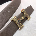 Taupe leather belt with textured grain and silver-tone engraved buckle