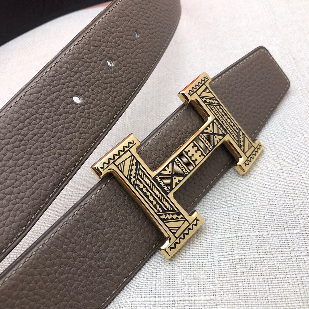 Taupe leather belt with textured grain and silver-tone engraved buckle