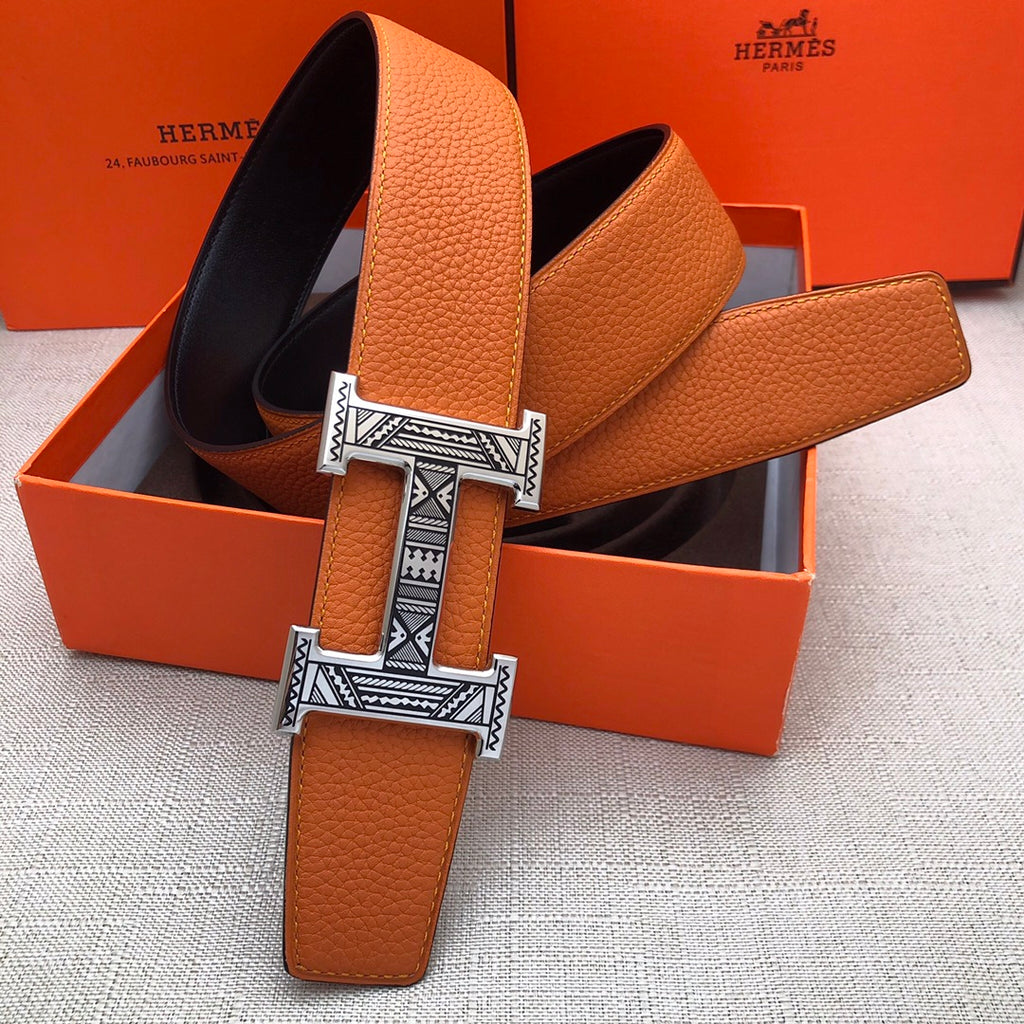 Hermes orange leather belt with H buckle and black-lined underside in orange box
