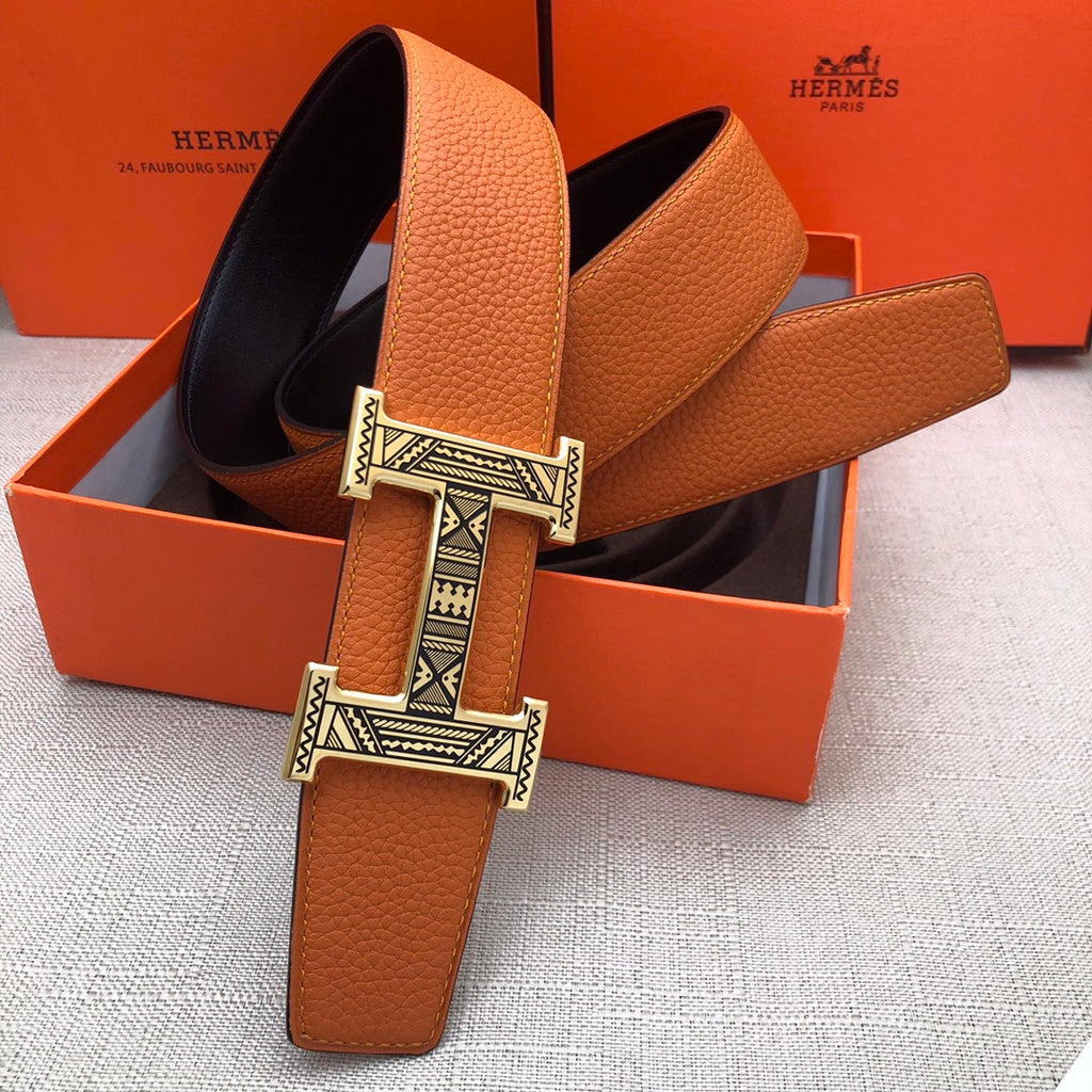 Hermes leather belt with orange strap and wide H buckle, shown in gift box