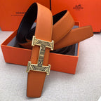 Hermes leather belt with orange strap and wide H buckle, shown in gift box