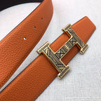 Hermes belt detail: orange textured leather with ornate H buckle and gold-tone hardware