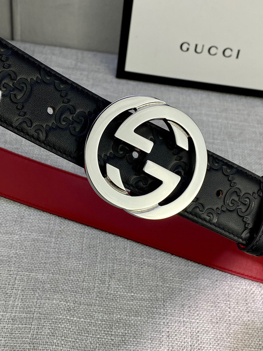 Gucci belt close-up: black embossed leather with silver-tone GG buckle