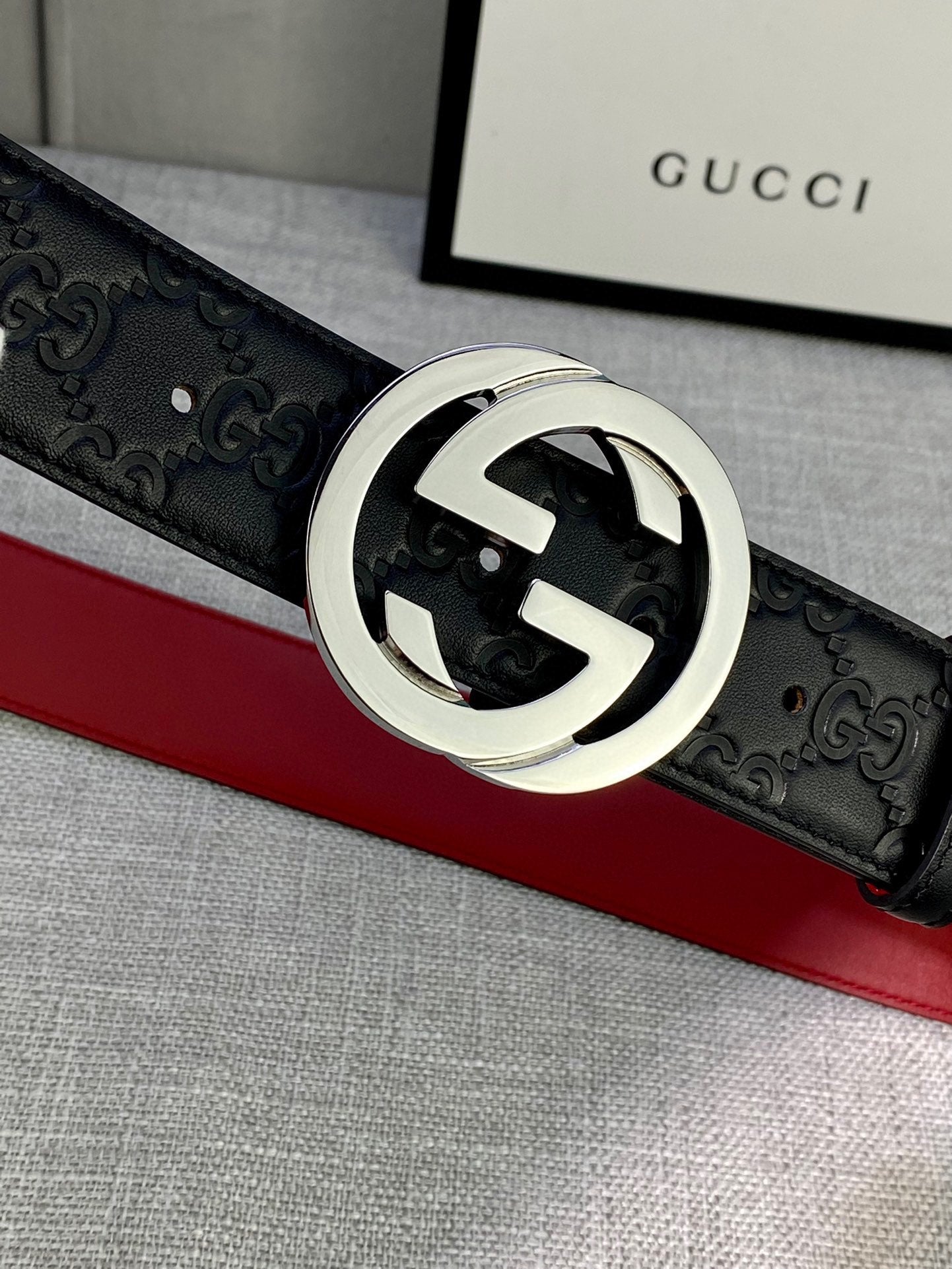 Gucci belt close-up: black embossed leather with silver-tone GG buckle