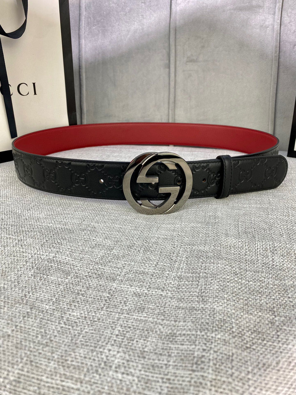 Gucci belt in black leather with embossed pattern, silver-tone GG buckle, red underside