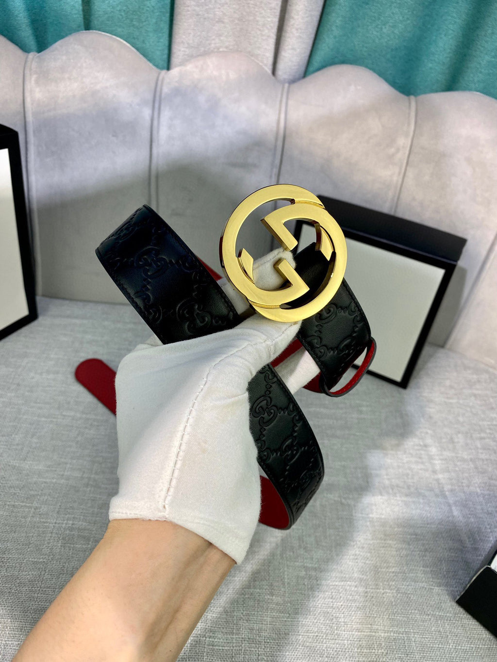 Gucci belt with black embossed leather and gold-tone GG buckle, red underside