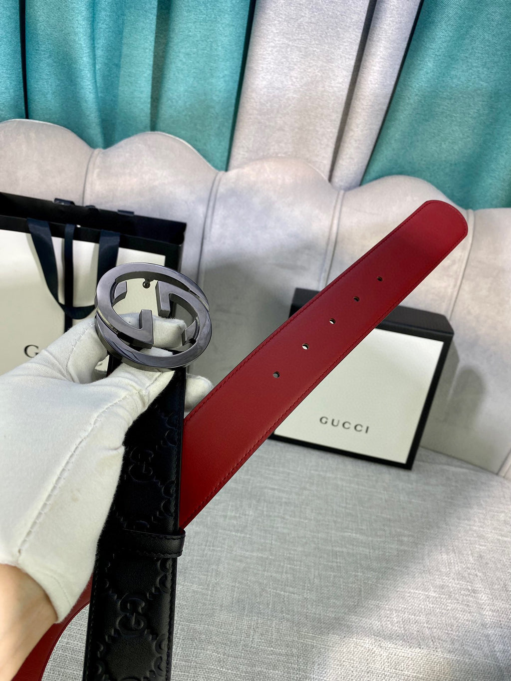 Gucci belt with black embossed leather strap and silver-tone GG buckle, red underside