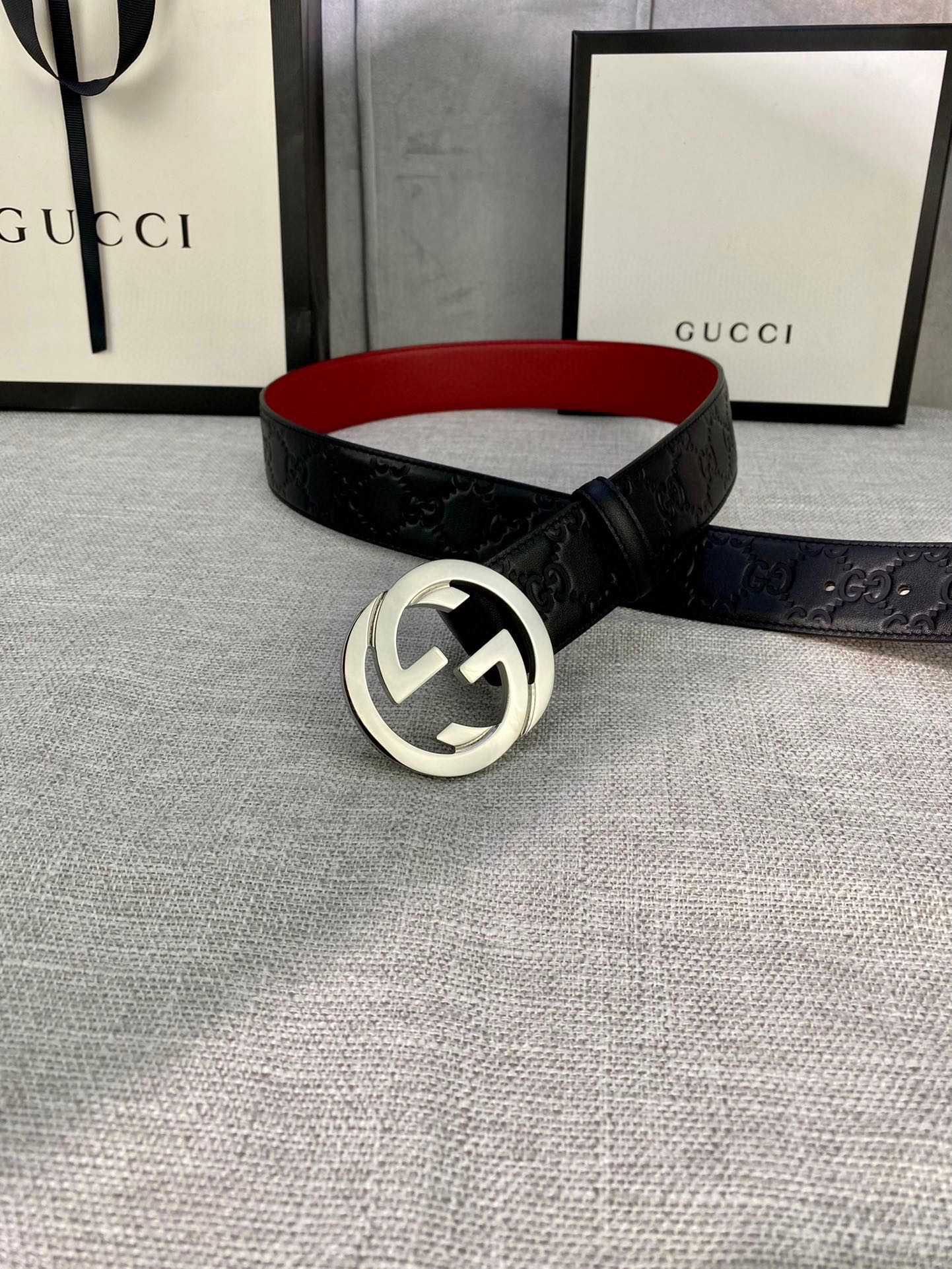Gucci belt with black embossed leather strap and silver-tone GG buckle, red underside