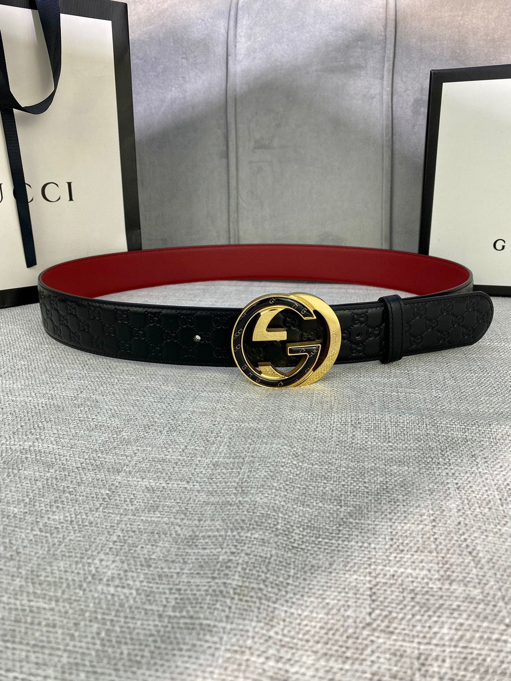 Gucci belt in black textured leather with gold-tone double-G buckle and red underside