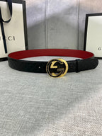 Gucci belt in black textured leather with gold-tone double-G buckle and red underside