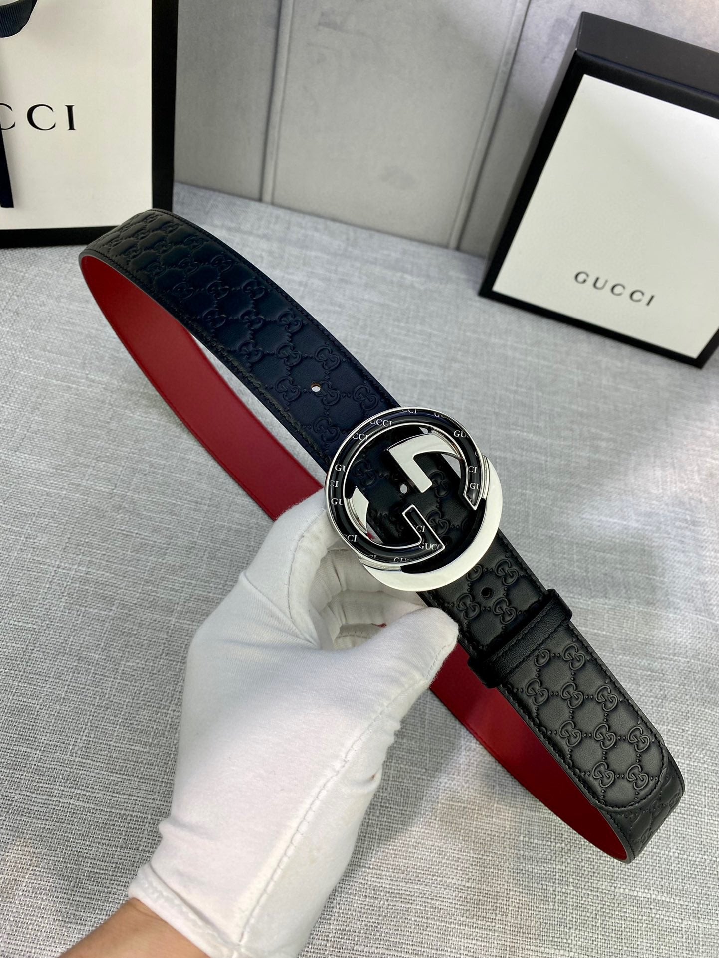 Gucci belt close-up: black leather with red inner strap and silver-toned buckle