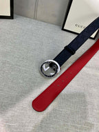Navy Gucci-logo belt with circular silver-tone buckle and red underside