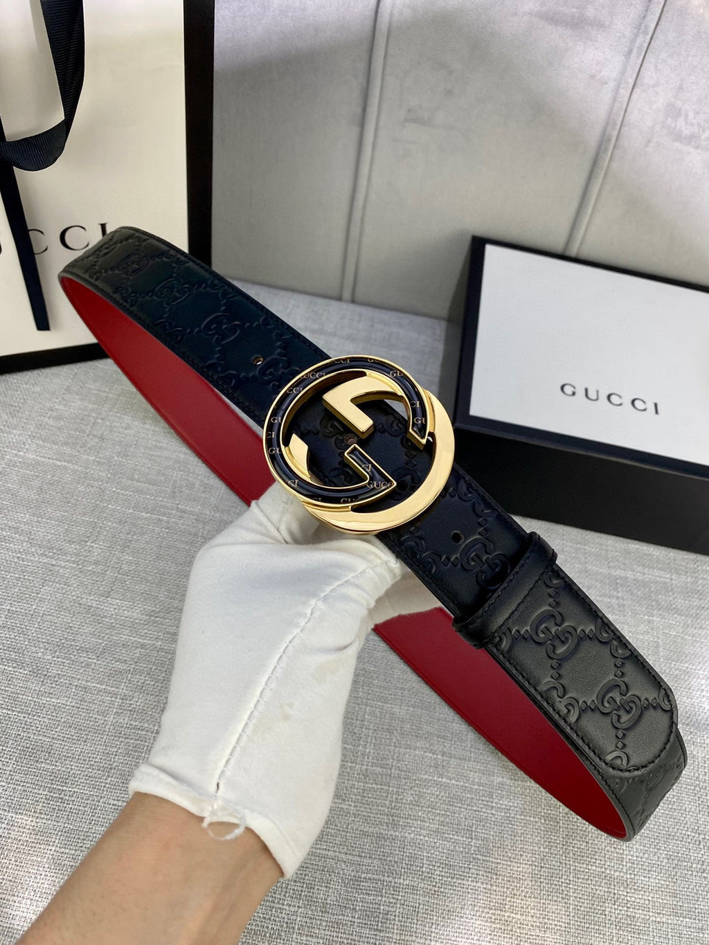 Black Gucci-logo belt with gold-tone and silver-tone oval buckle detail