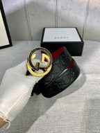 Black Gucci-logo belt with gold-tone circular buckle and embossed strap