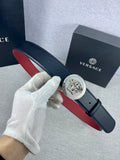 Versace leather belt with round gold buckle featuring Medusa-style face, dark blue strap