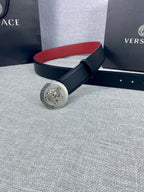 Versace leather belt with round gold Medusa-style buckle and dark strap, red underside