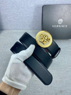 Versace leather belt stacked view: dark strap with red underside and gold Medusa-style buckle