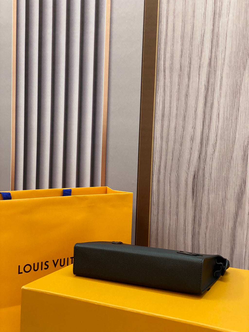 Louis Vuitton leather clutch, black with zipper closure and cylindrical hardware pull