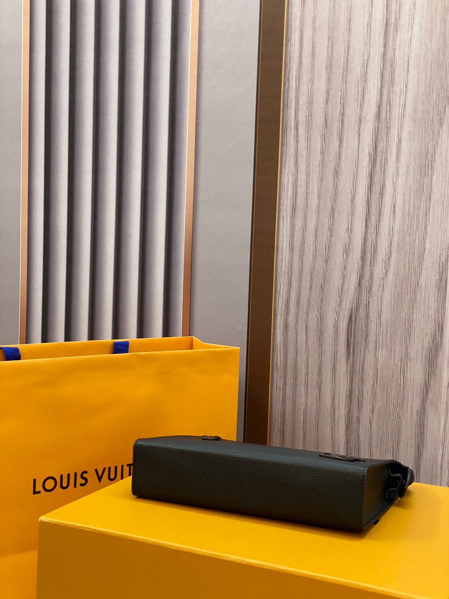 Louis Vuitton leather clutch, black with zipper closure and cylindrical hardware pull