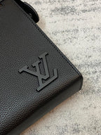 Louis Vuitton embossed logo on black textured leather corner