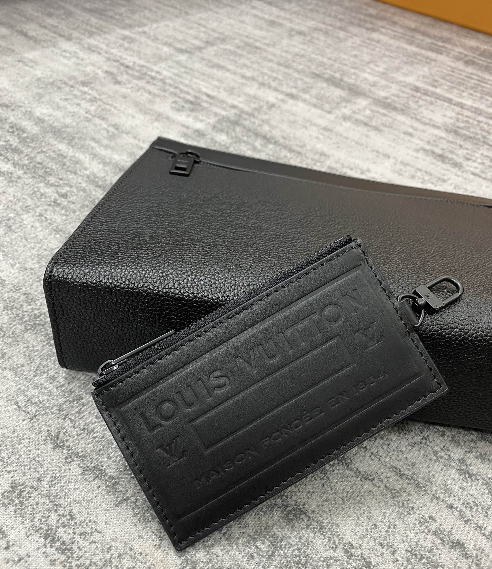 Louis Vuitton leather card case, black textured finish with embossed logo panel