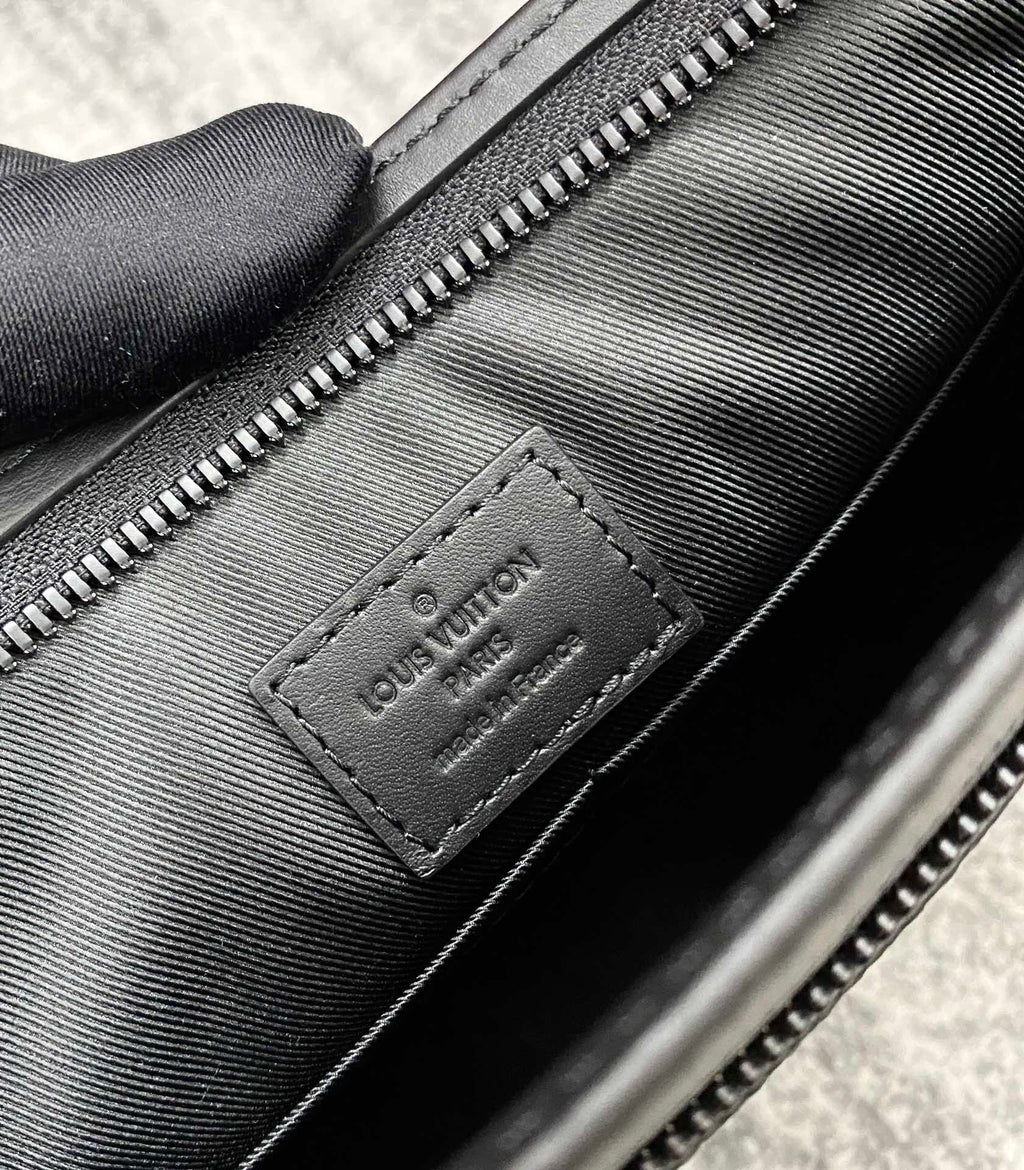 Louis Vuitton leather interior tag, black with embossed logo and zipper seam