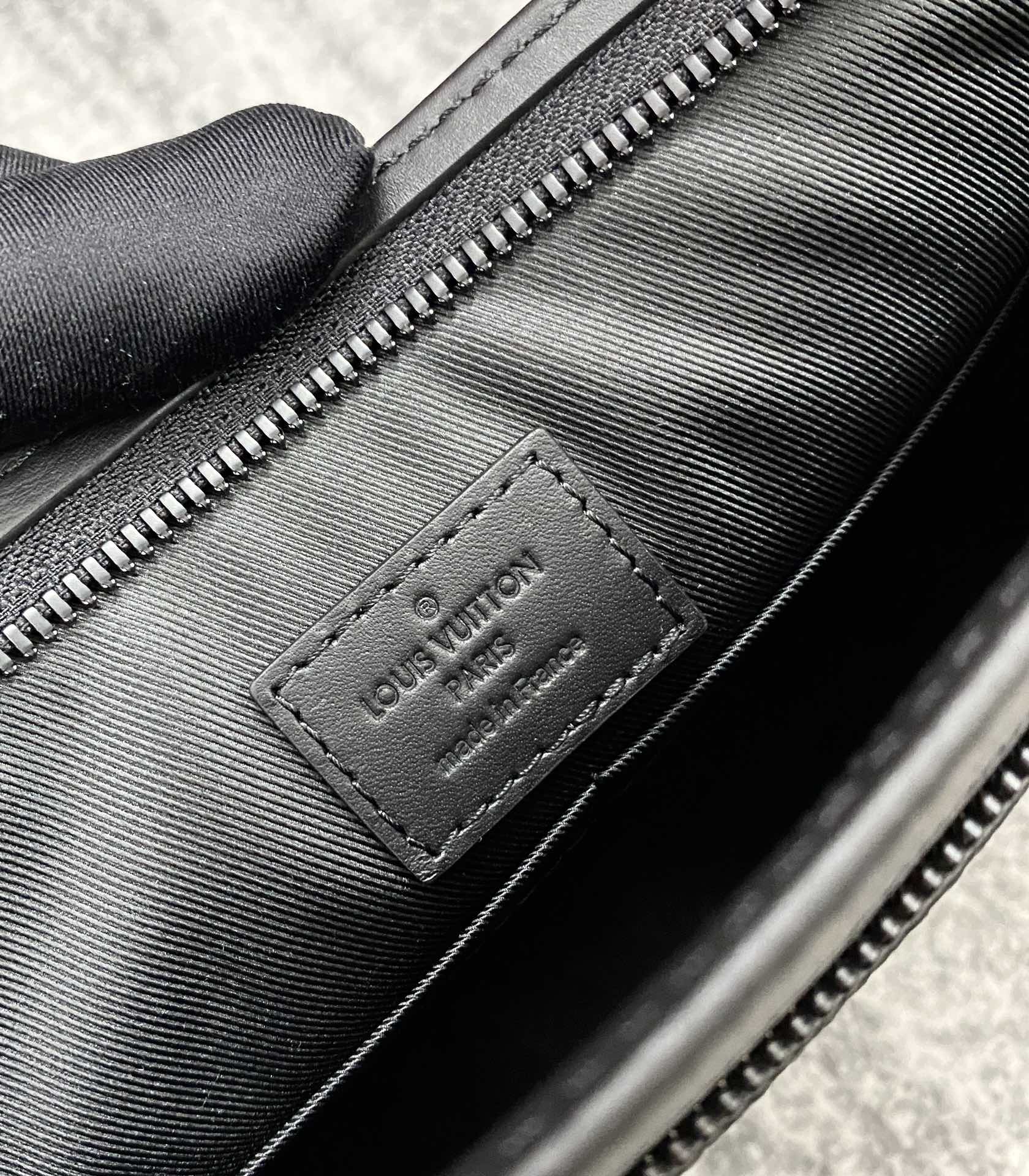 Louis Vuitton leather interior tag, black with embossed logo and zipper seam
