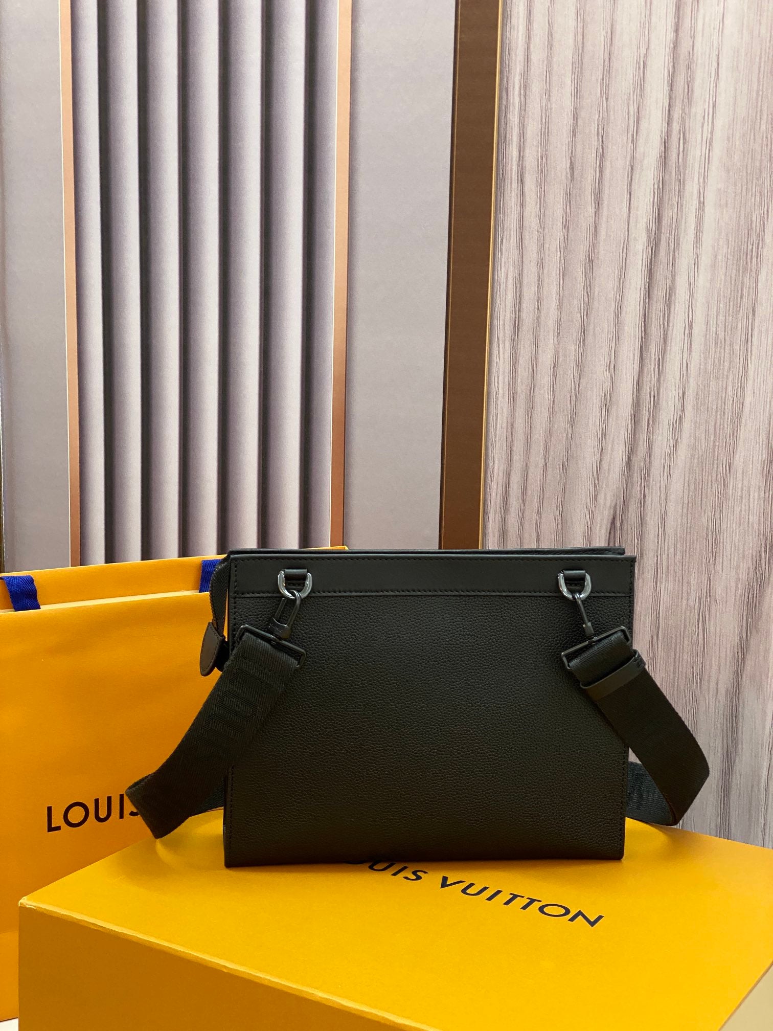 Louis Vuitton leather crossbody bag, black front view with rings and shoulder strap