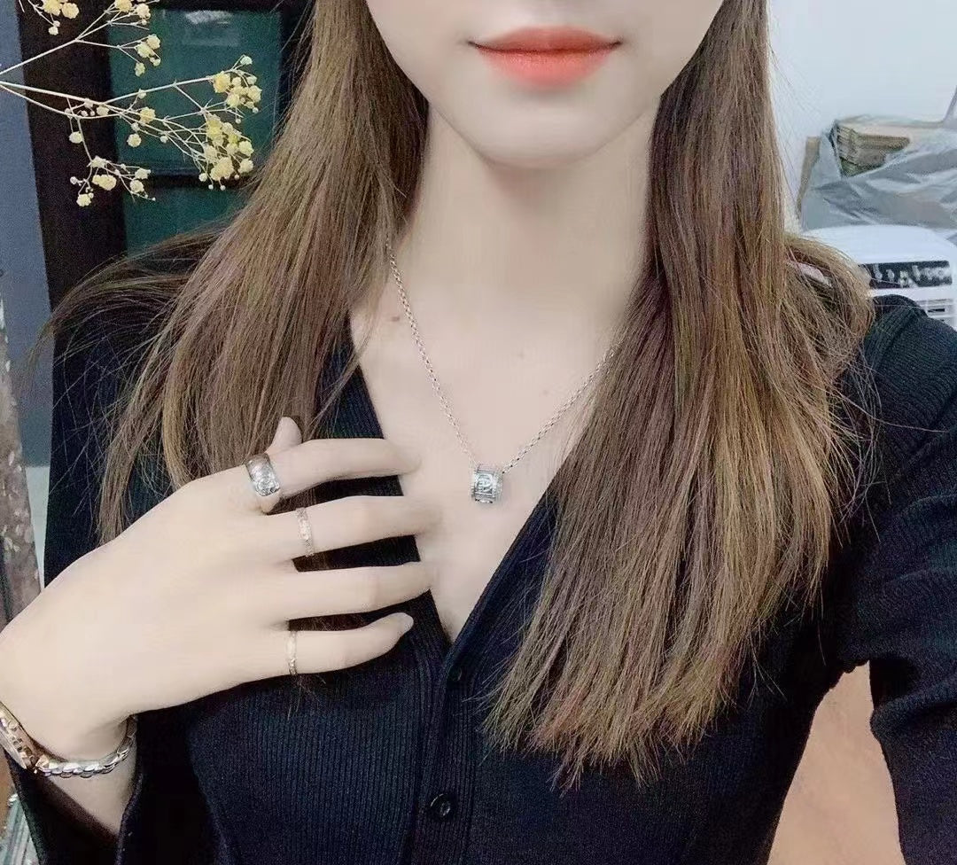 Gucci necklace worn by model, silver chain with small logo pendant