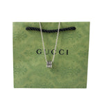 Gucci necklace on green gift bag, silver chain and logo pendant