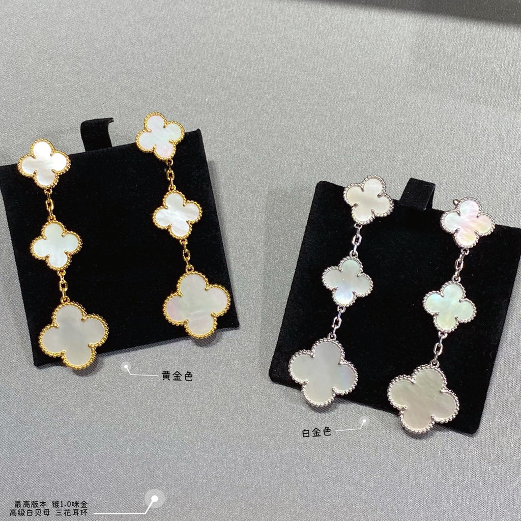 Clover dangle earrings in gold and silver, each with linked four-leaf motifs.