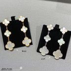 Clover dangle earrings in gold and silver, each with linked four-leaf motifs.