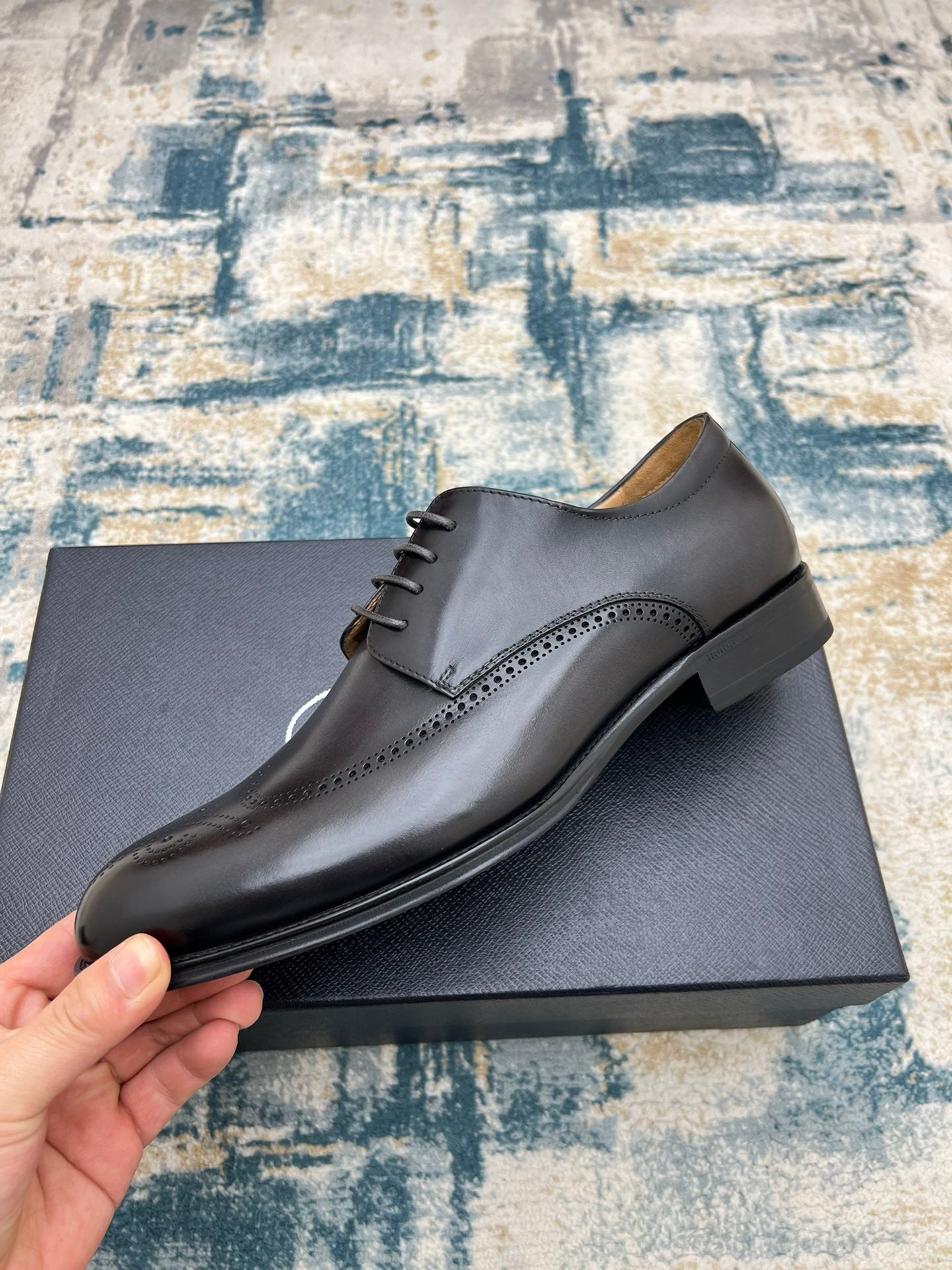 Prada unisex lace-up oxford shoe, dark leather with brogue perforations, on box