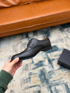 Prada lace-up dress shoe, dark leather, side profile with low heel and lace-up.