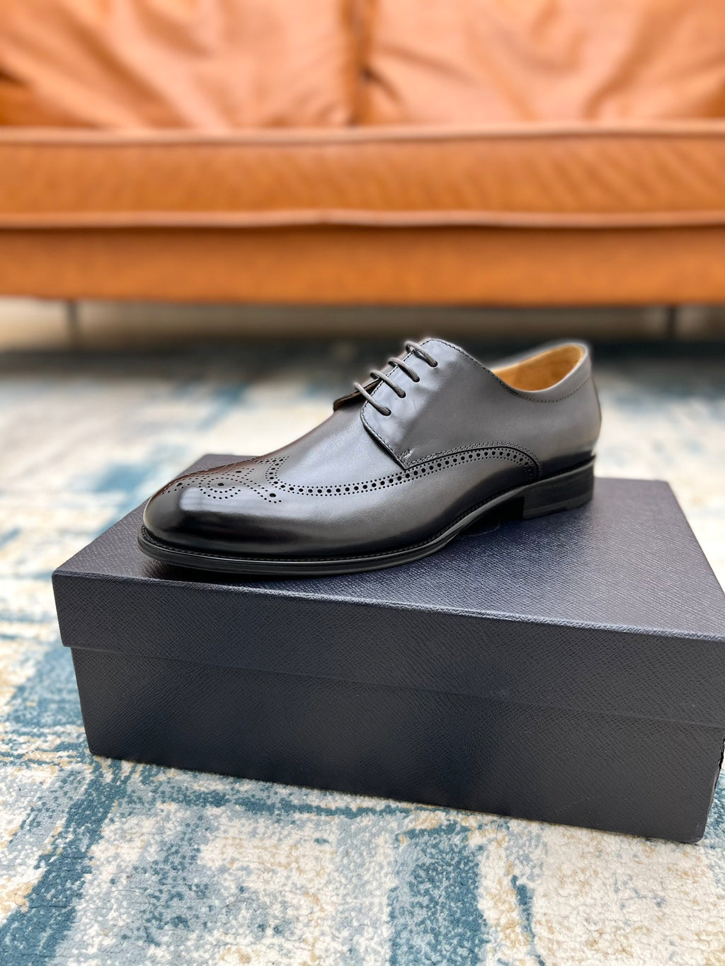 Prada unisex lace-up oxford shoe, dark leather with brogue perforations, on box