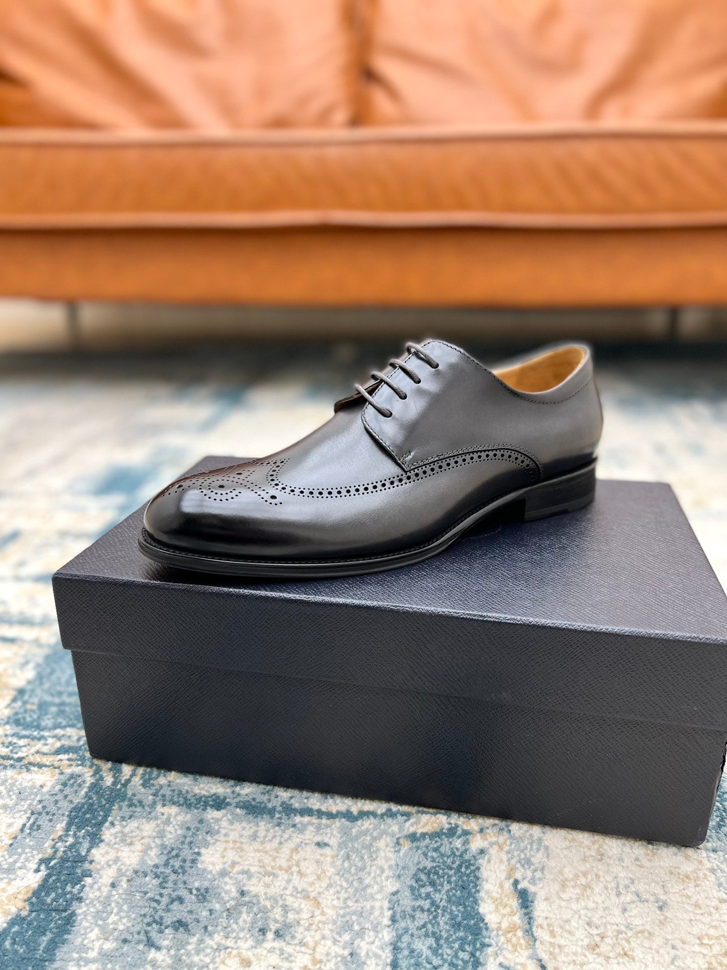 Prada unisex lace-up oxford shoe, dark leather with brogue perforations, on box