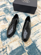 Black leather lace-up derby shoes with perforated toe, front view