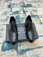 Black leather lace-up derby shoes with perforated toe and Prada logo