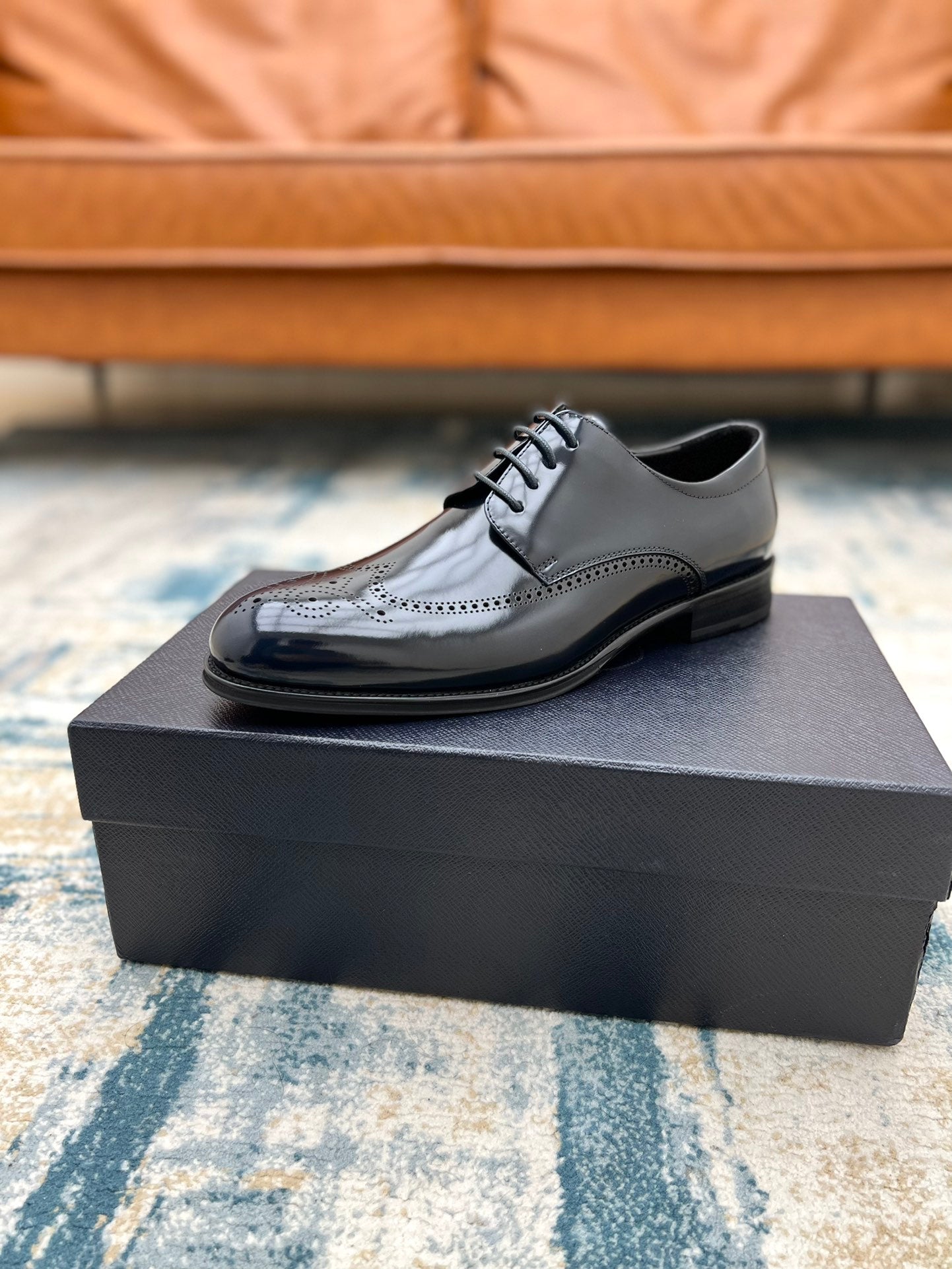 Prada dark leather lace-up dress shoe on box, polished finish with brogue trim
