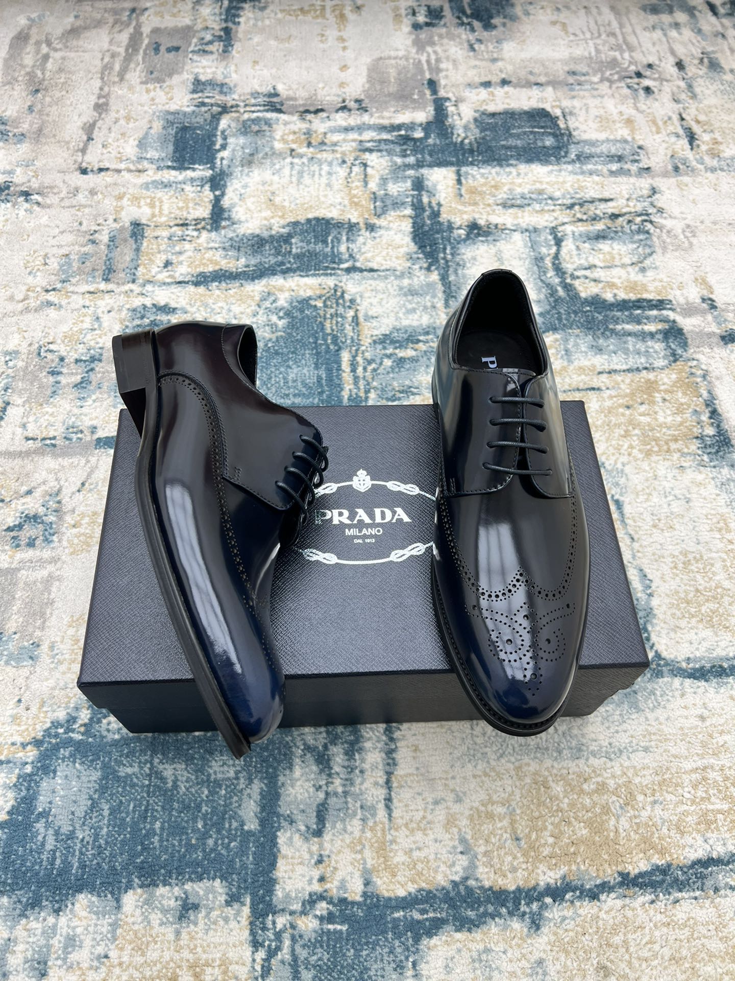 Prada lace-up leather derby shoes in dark leather with brogue perforations