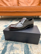 Prada unisex leather lace-up shoe with brogue detailing, side view on black box