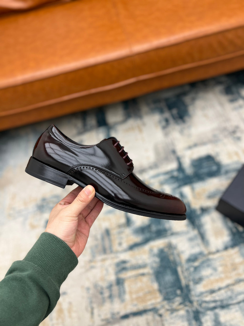 Prada unisex leather lace-up shoe on hand, side view with dark rubber sole