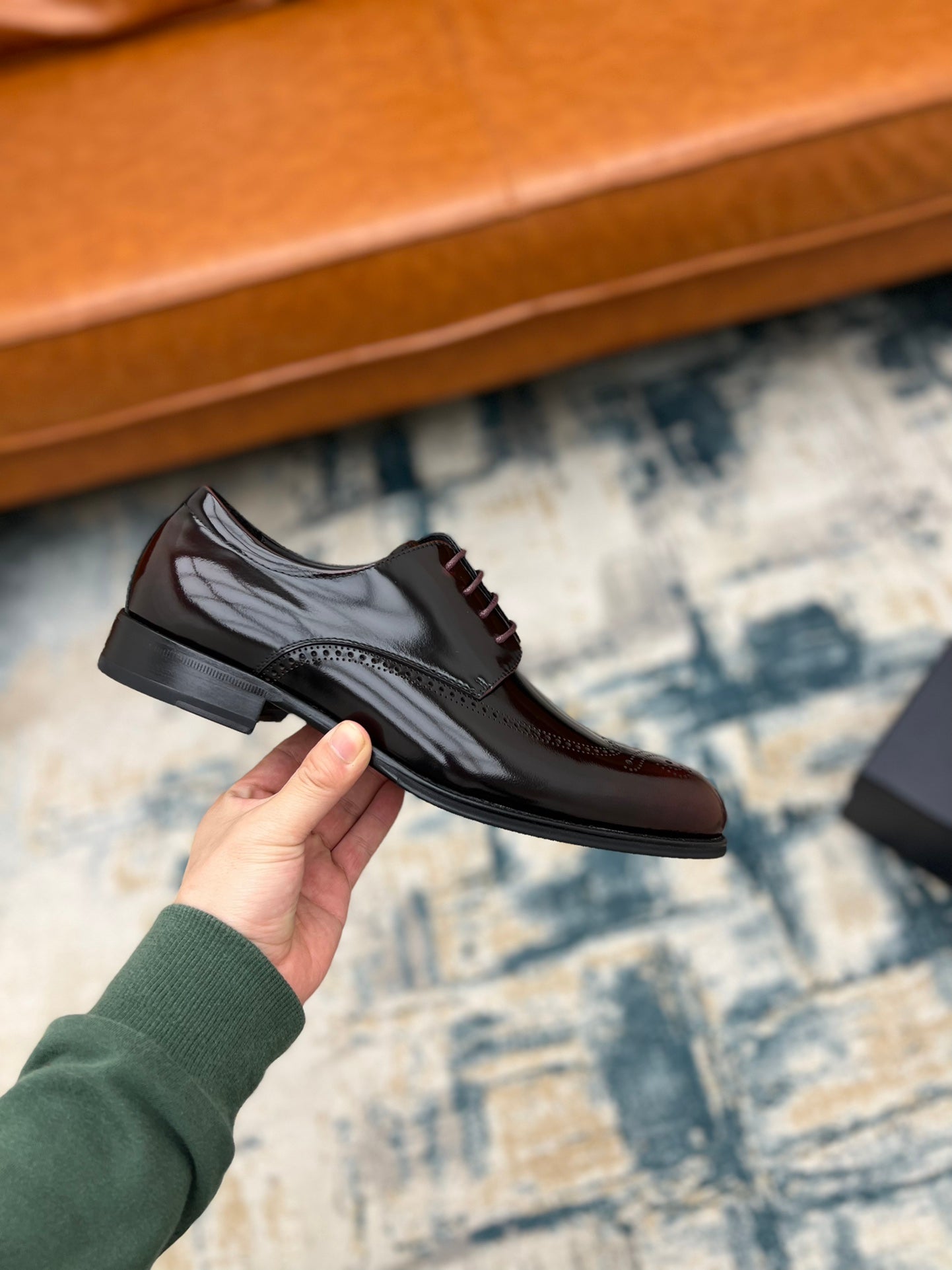 Prada unisex leather lace-up shoe on hand, side view with dark rubber sole