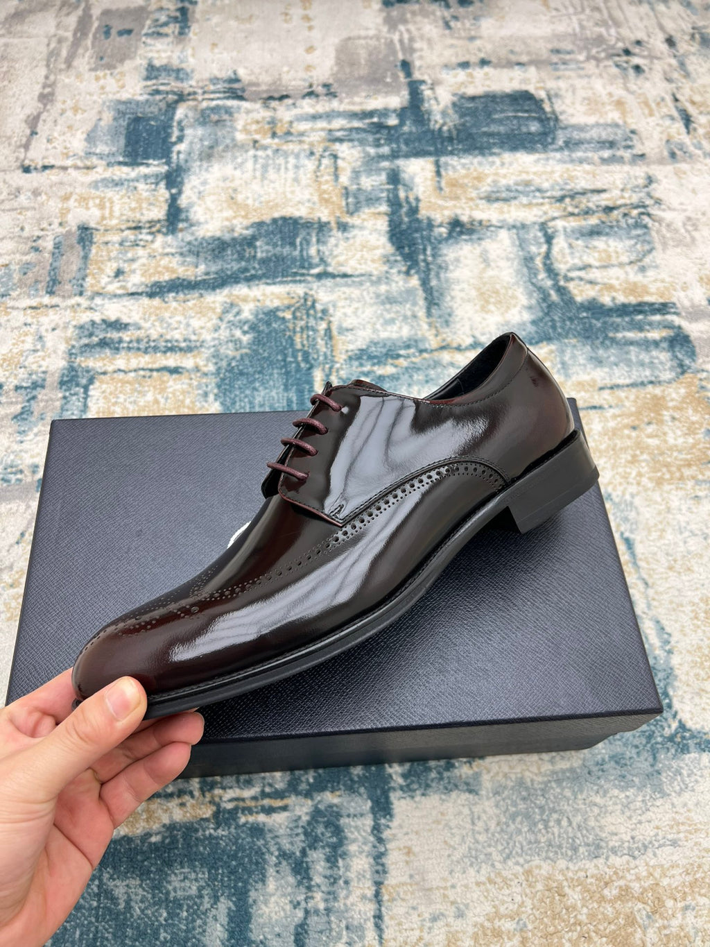 Prada unisex two-tone leather lace-up shoe on hand, side profile with brogue detailing