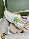 White Gucci unisex sneakers with blue and yellow star logo on side