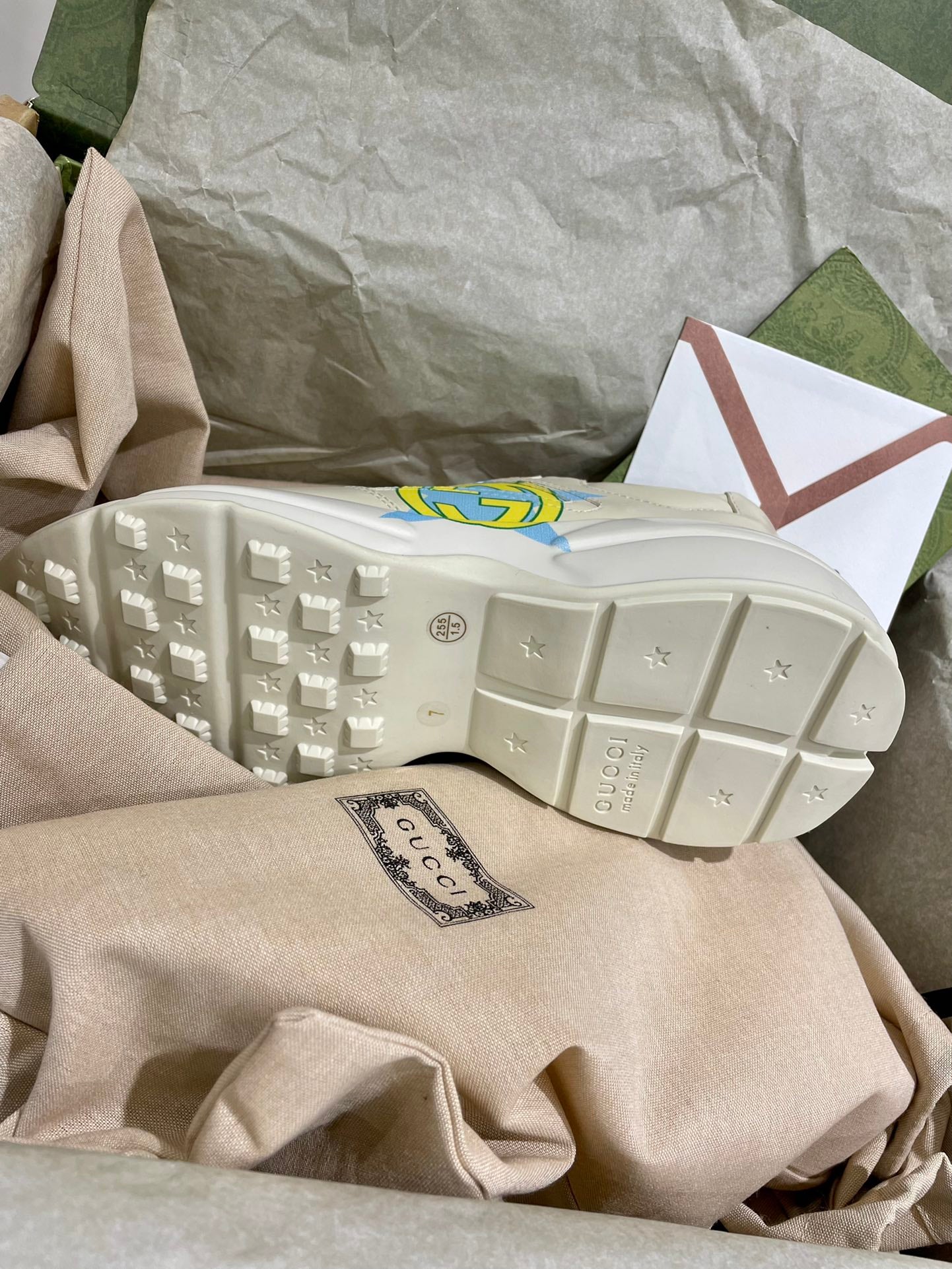 White Gucci unisex sneakers outsole view with tread pattern and star logo