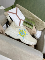 White Gucci unisex sneakers, side and lace details with blue-yellow star logo