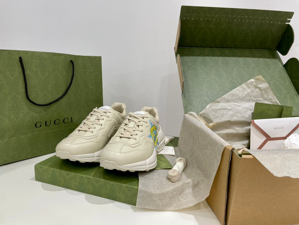 White Gucci unisex sneakers with lace-up front and blue-yellow star logos