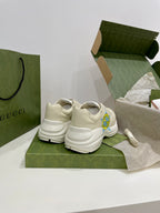 White Gucci unisex sneakers with blue-yellow star logo, heel and back view